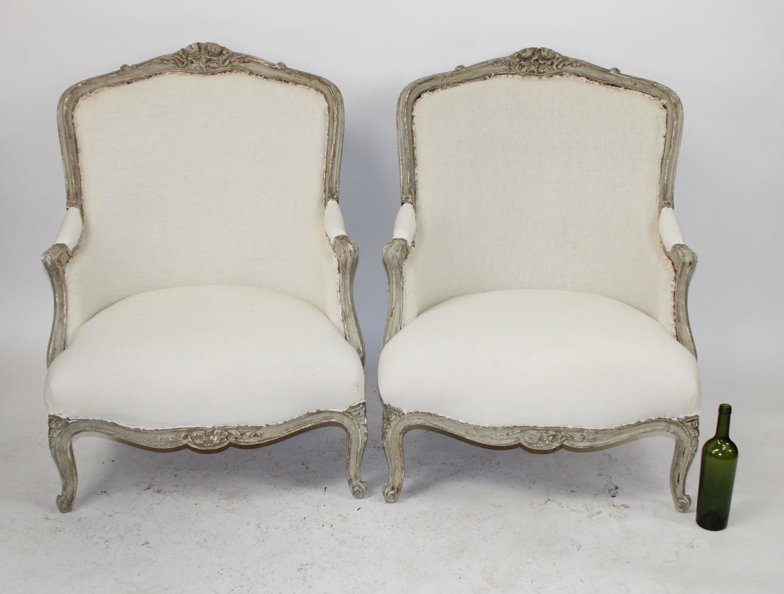 Pair of French Louis XV bergere armchairs: Pair of French Louis XV style bergere armchairs on painted frames with muslin upholstery. Early 20th century. 37"h x 28 1/2"w x 32"d