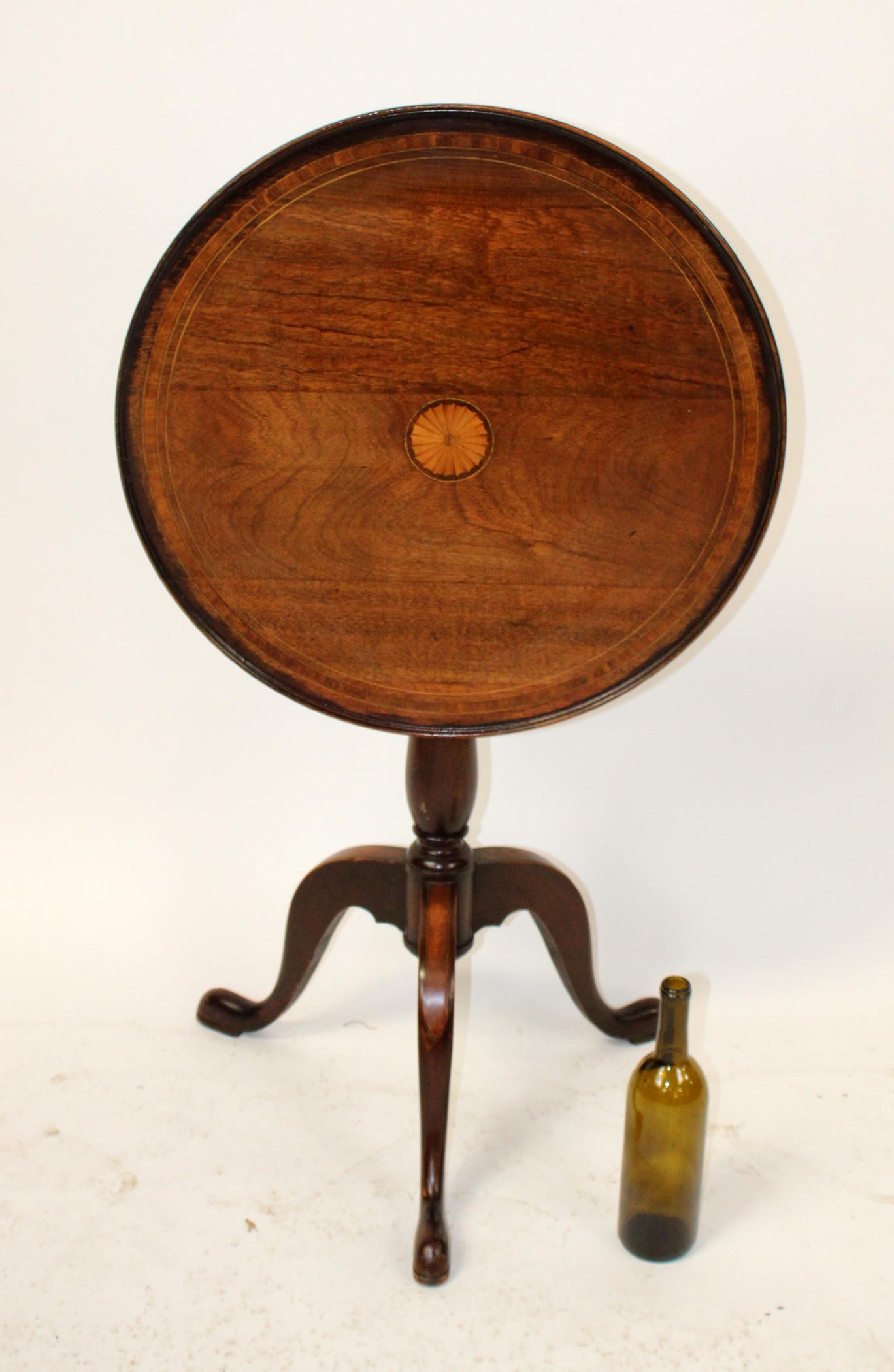 English Edwardian inlaid mahogany tilt top table: English Edwardian tilt top table in mahogany with inlaid satinwood center. Early 20th century. 29"h x 23" dia, Height of table tilted up 41"