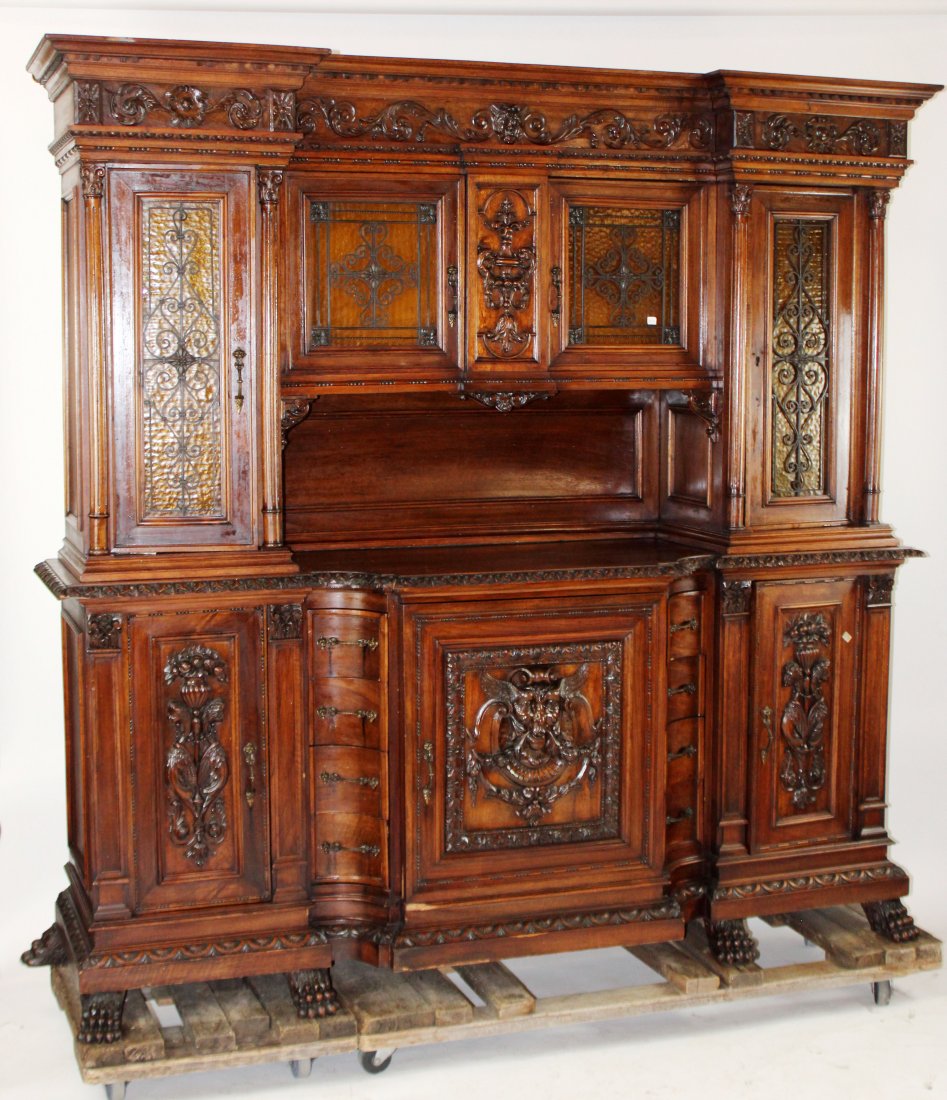 Italian Renaissance buffet in carved walnut: Italian Renaissance buffet in carved walnut with iron grill over amber glass doors, mythological mask carvings and paw feet. Late 19th century. 83"h x 83 1/2"w x 22 1/2"d