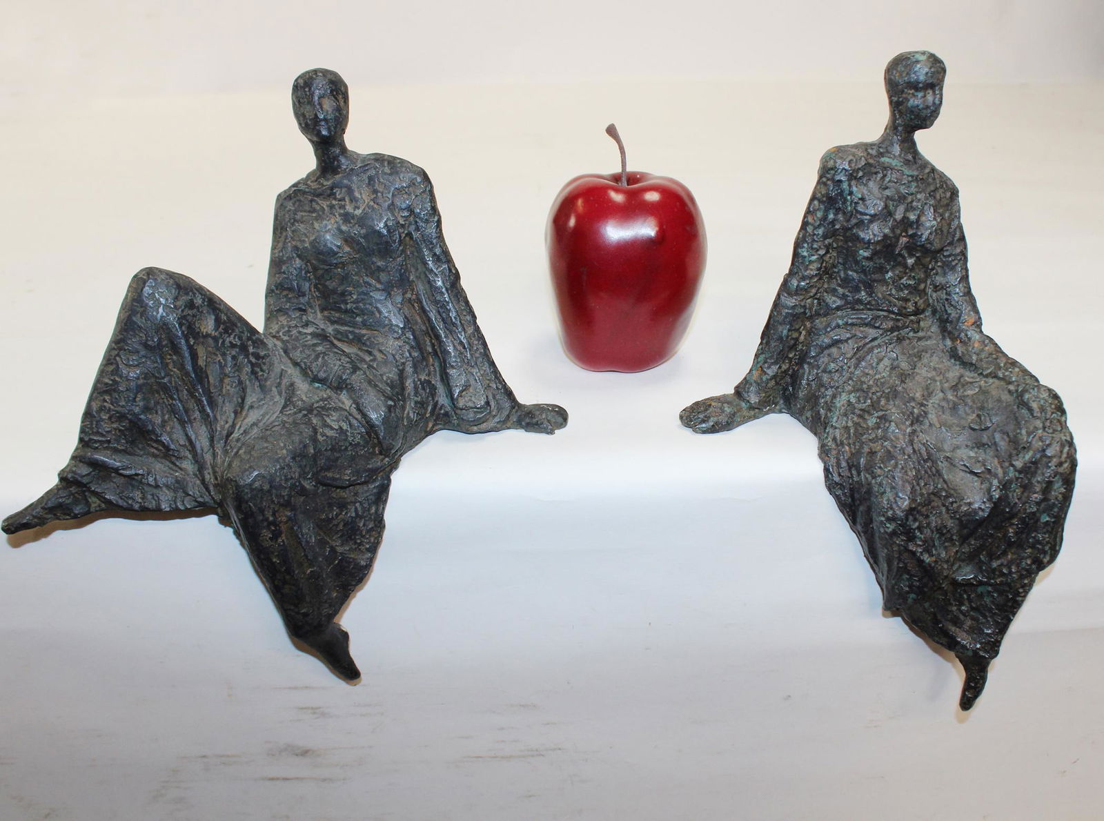 Pair of cast bronze figural seated statues: Pair of cast bronze figural seated statues after Henry Moore. 11"h x 7"w