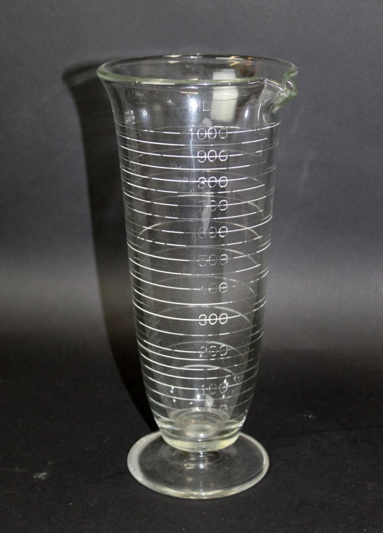 American glass apothecary measuring beaker: American glass apothecary footed measuring beaker. 20th century. 11"h x 5" dia