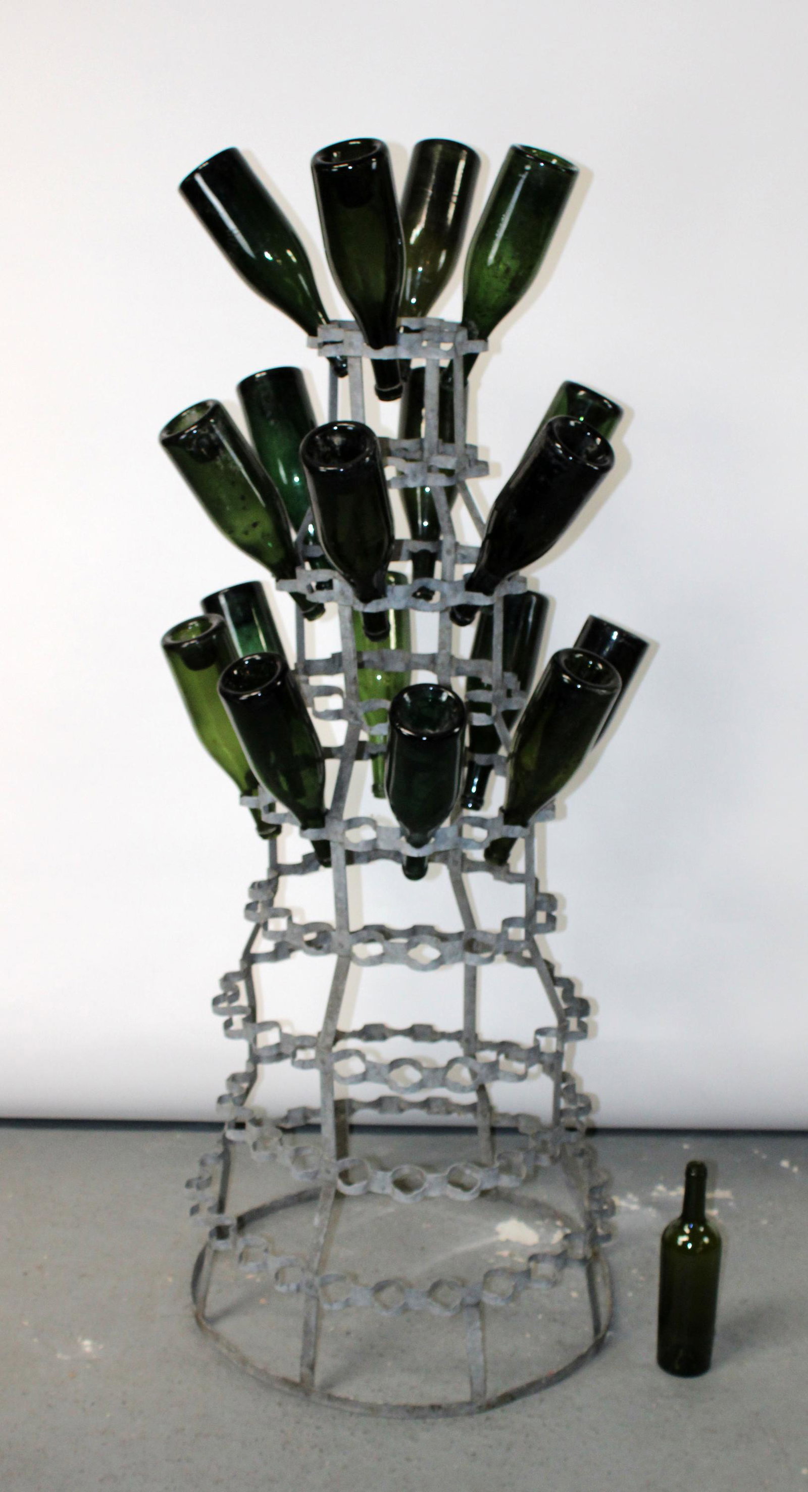 Vintage French bottle drying rack with 18 bottles: Vintage French bottle drying rack from Paris and 18 French green glass wine bottles. Mid 20th century. Rack 53"h x 23 1/2"dia. Bottles 12"h,