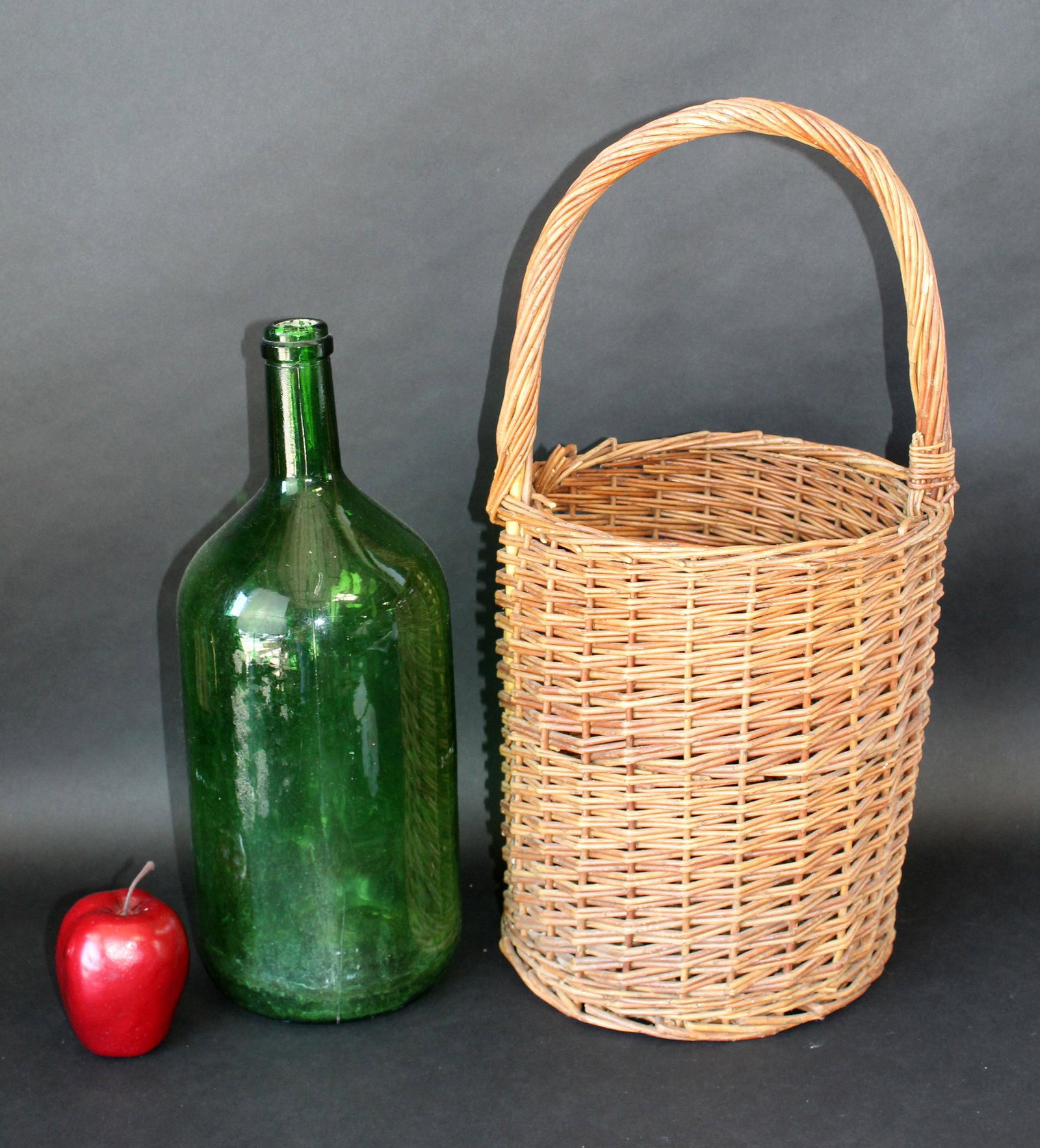 French wine bottle in wicker basket: French wine bottle in wicker basket. Late 20th century. basket 21"h x 11"w, bottle 17"h x 6"w
