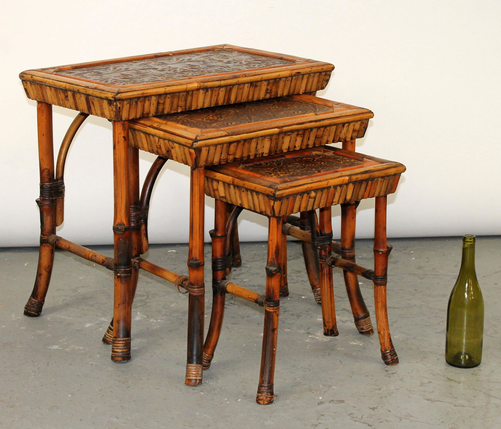 Nest of 3 bamboo tables: Nest of 3 tables with bamboo legs and embossed tops.24"-18"h x 25"-15"w x 16" x 10 1/2"d
