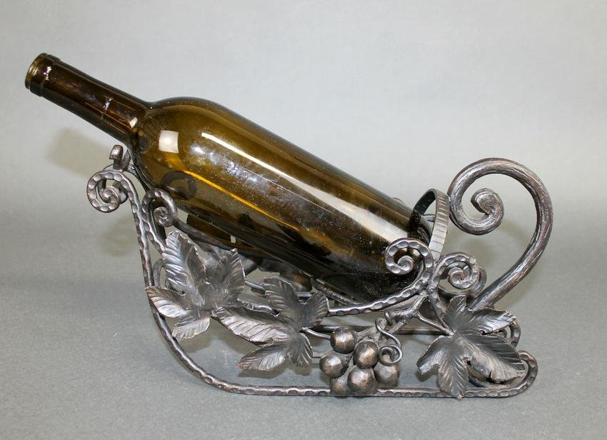 French wrought iron wine bottle caddy: French wrought iron wine bottle caddy or holder with grape motif. Mid 20th century. 6 1/2"h x 12 1/2"w x 6 1/4"d