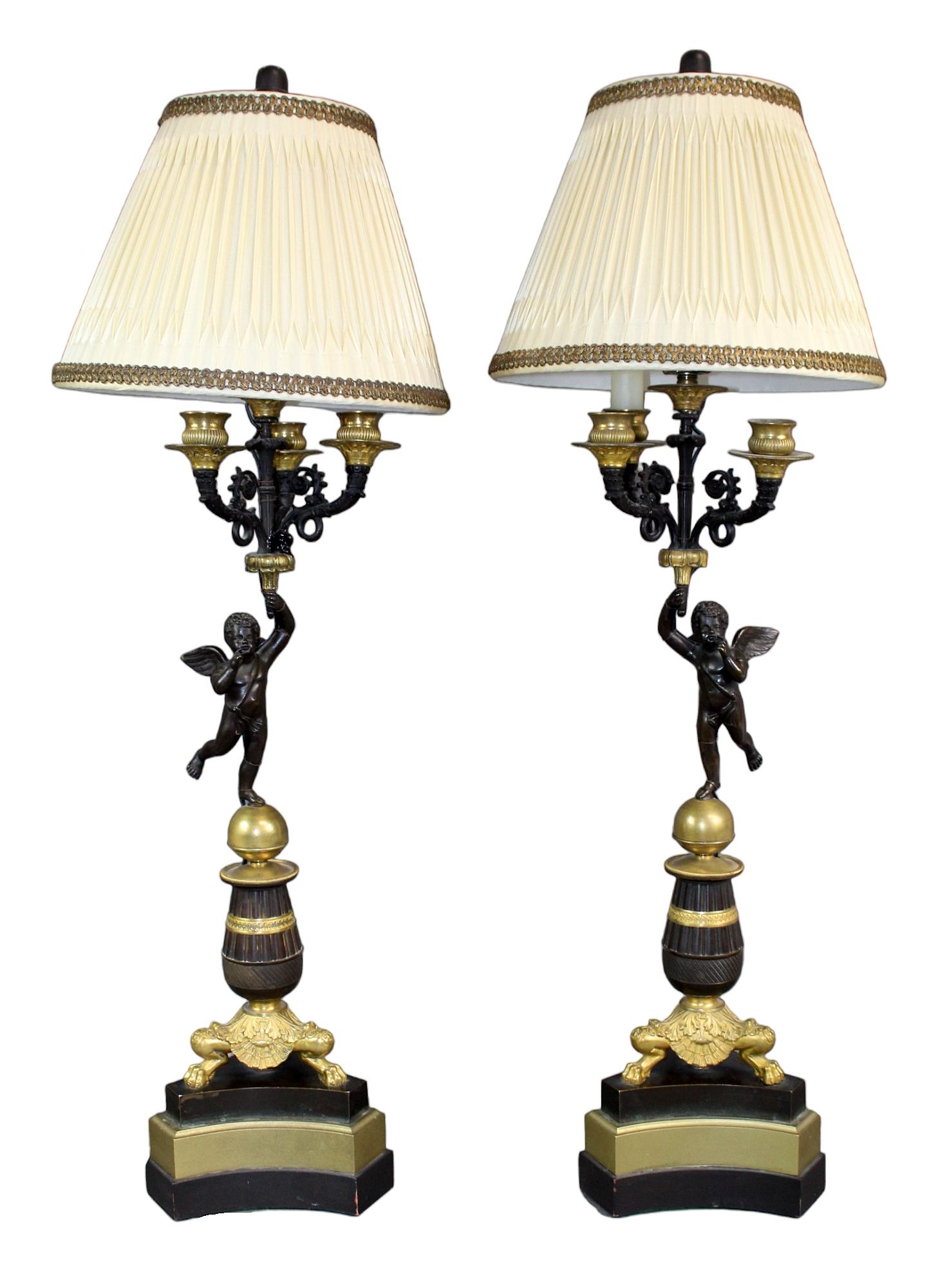 Pair French Empire bronze candelabra with cherubs mounted as lamps: Pair French Empire bronze candelabra with cherubs mounted as lamps. Late 19th century, later mounted as lamps. 30 1/2" h x 10 1/4" diam