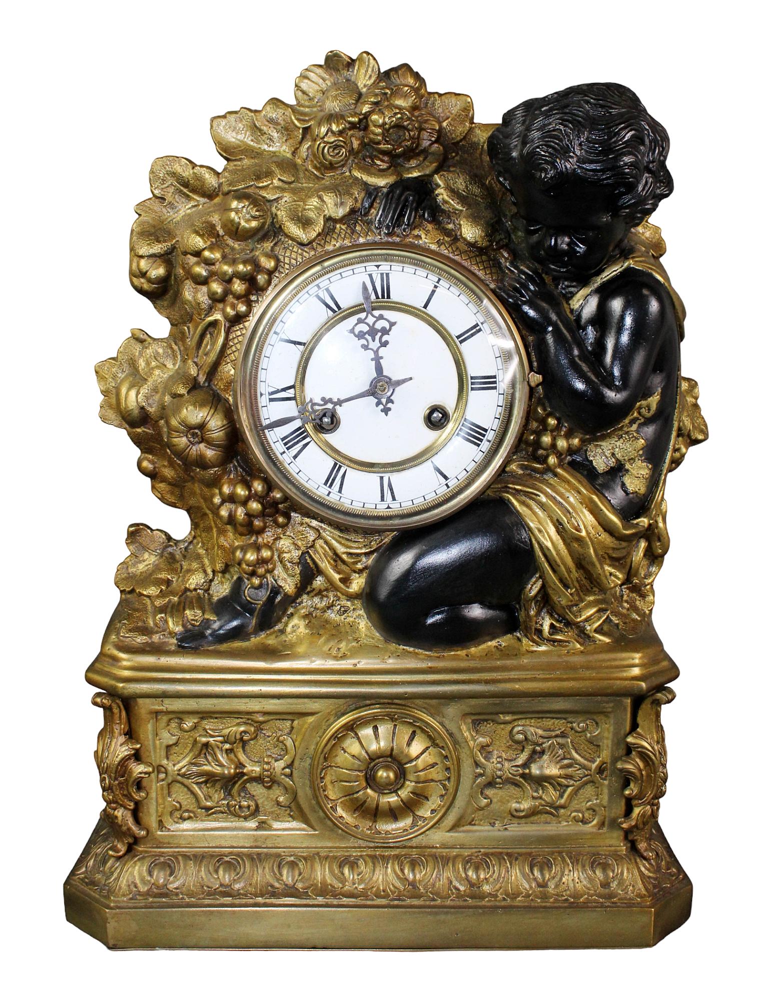 French bronze mantel clock with cherub: French bronze mantel clock with cherub & flower garland. Early 20th century. 19" h x 13 3/4" w x 5 1/2" d
