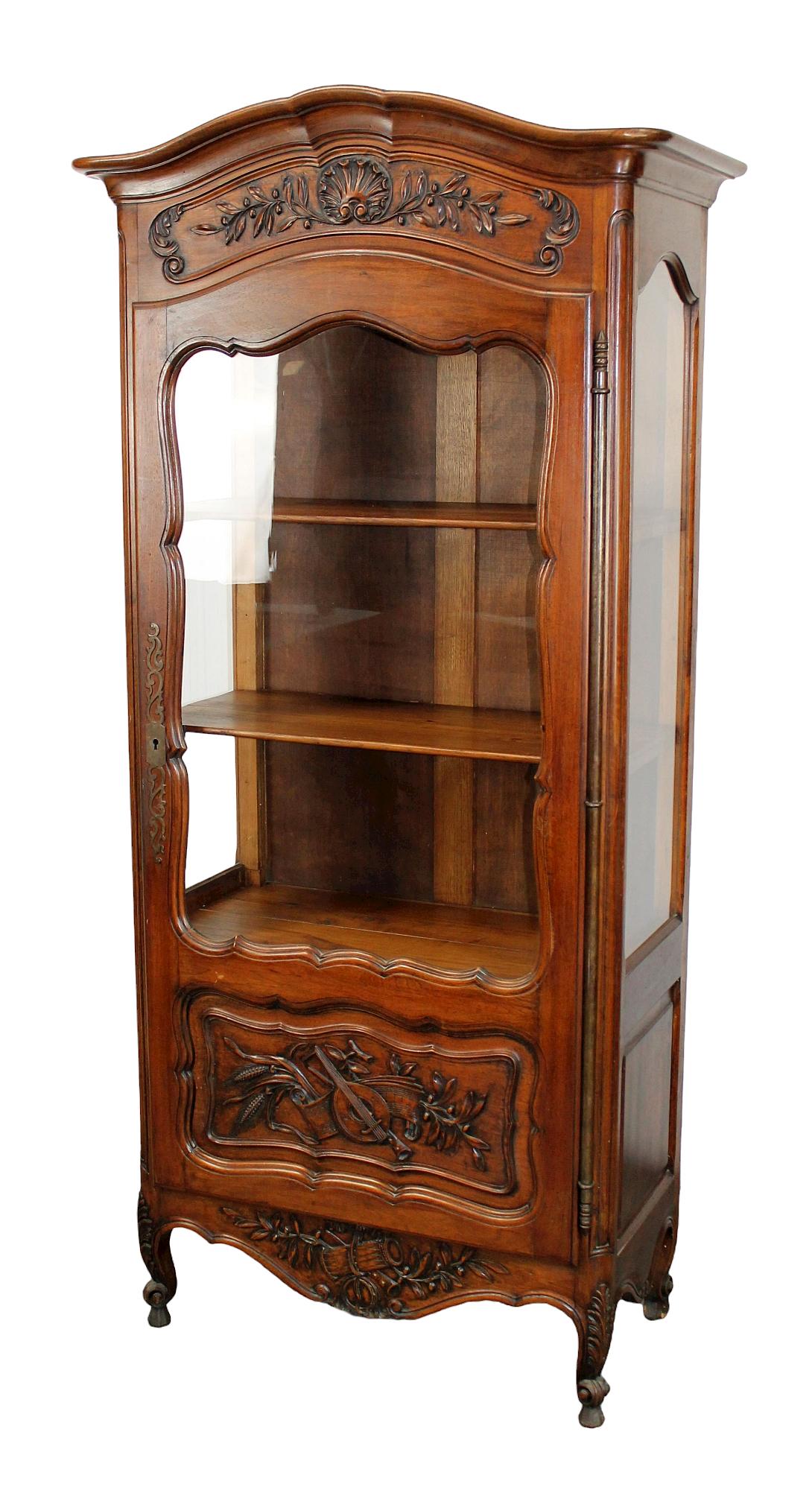 French Provincial carved walnut vitrine: French Provincial carved walnut vitrine with musical carvings. Early 20th century. 74"x 34"w x 18"d