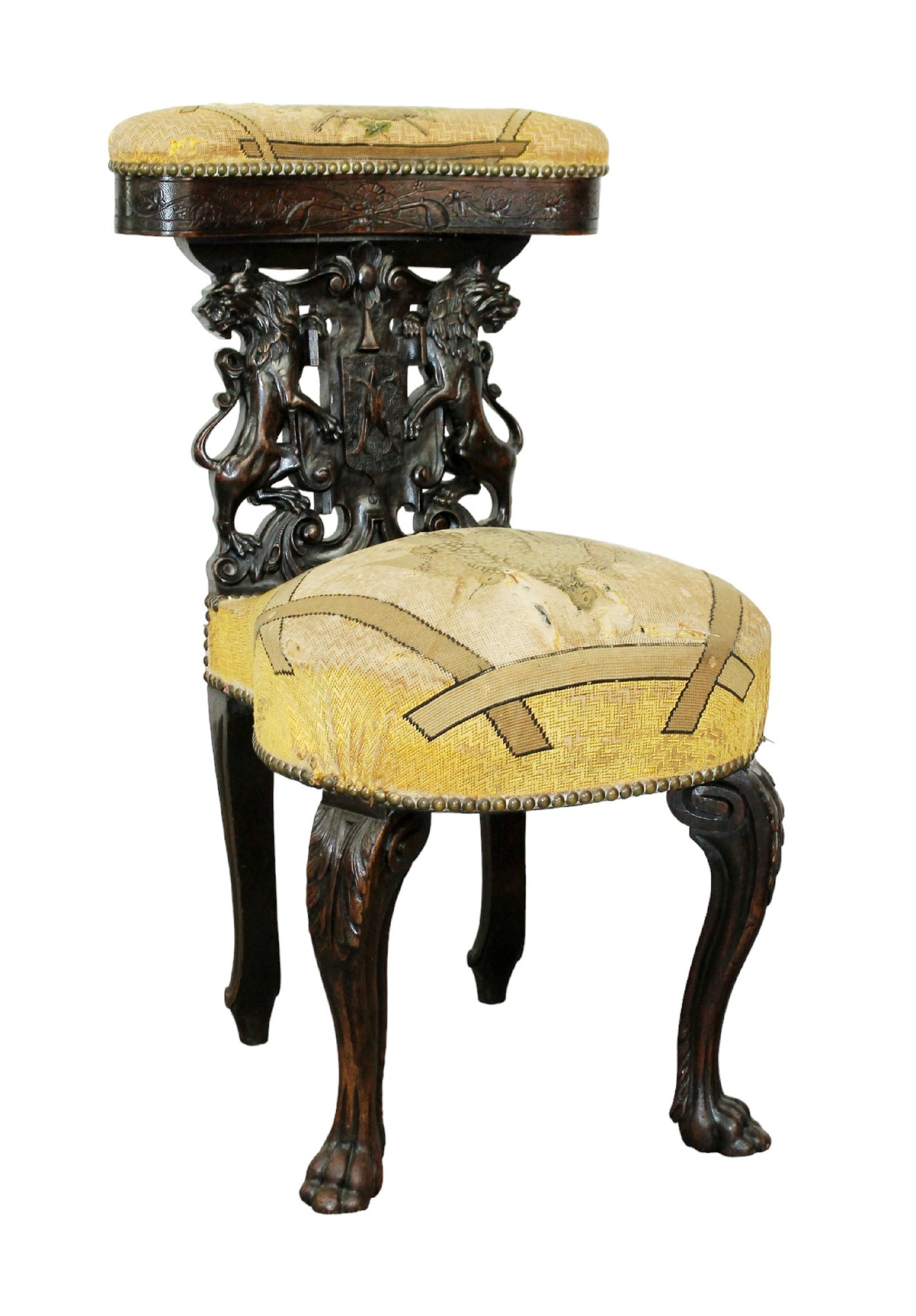French carved walnut smoking chair with lions and needlepoint: French carved walnut smoking chair with lions flanking shield and paw feet. Needlepoint upholstery. 19th century. 33"h x 17"w x 21"d, seat height 19 1/2"