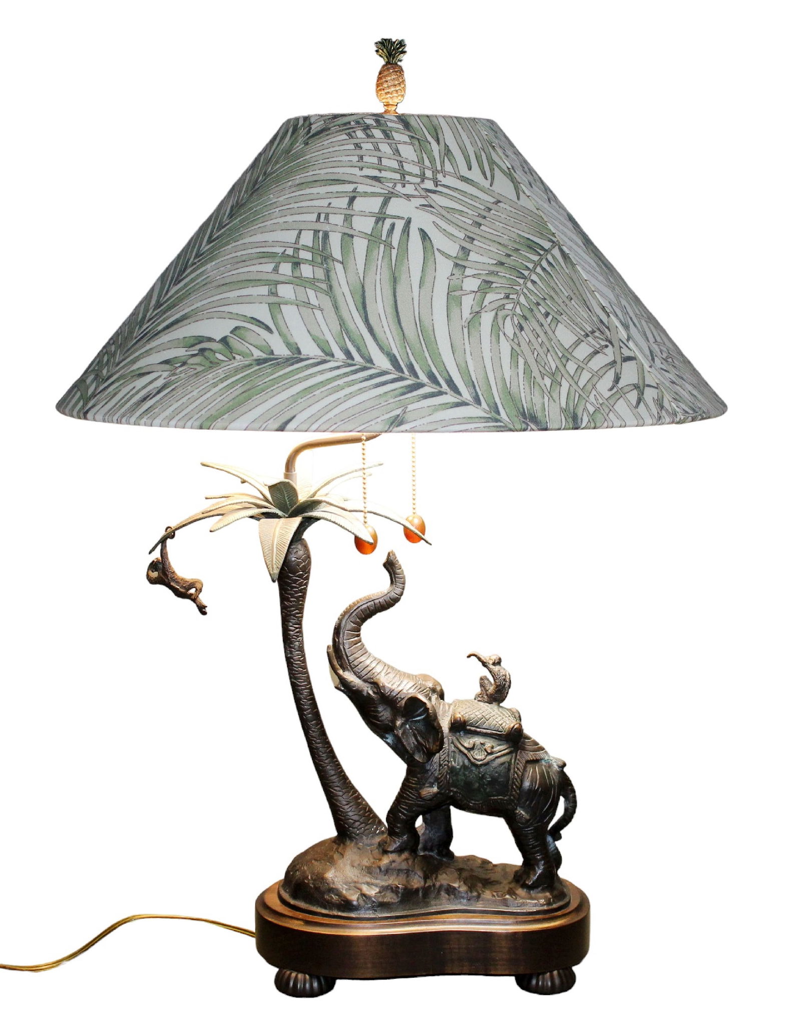 Frederick Cooper table lamp with bronze elephant, monkeys, and palm tree: Frederick Cooper table lamp with bronze elephant, monkeys, and palm tree. Pineapple finial. Lamp: 32 1/8"h x 15 1/2"w x 9 5/8"d. Shade: 9 3/8"h x 22 1/8"diameter. Overall weight: 14lbs