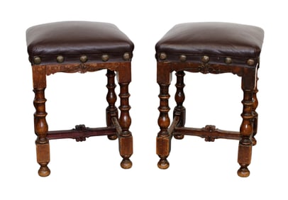 Pair of French carved walnut stools with leather seats.