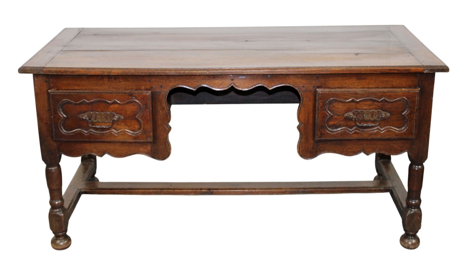 French Provincial desk in oak: French Provincial desk in oak. With carved scalloped knee hole opening. Early 20th century. 30"h x 59 1/2"l x 26 1/2"d