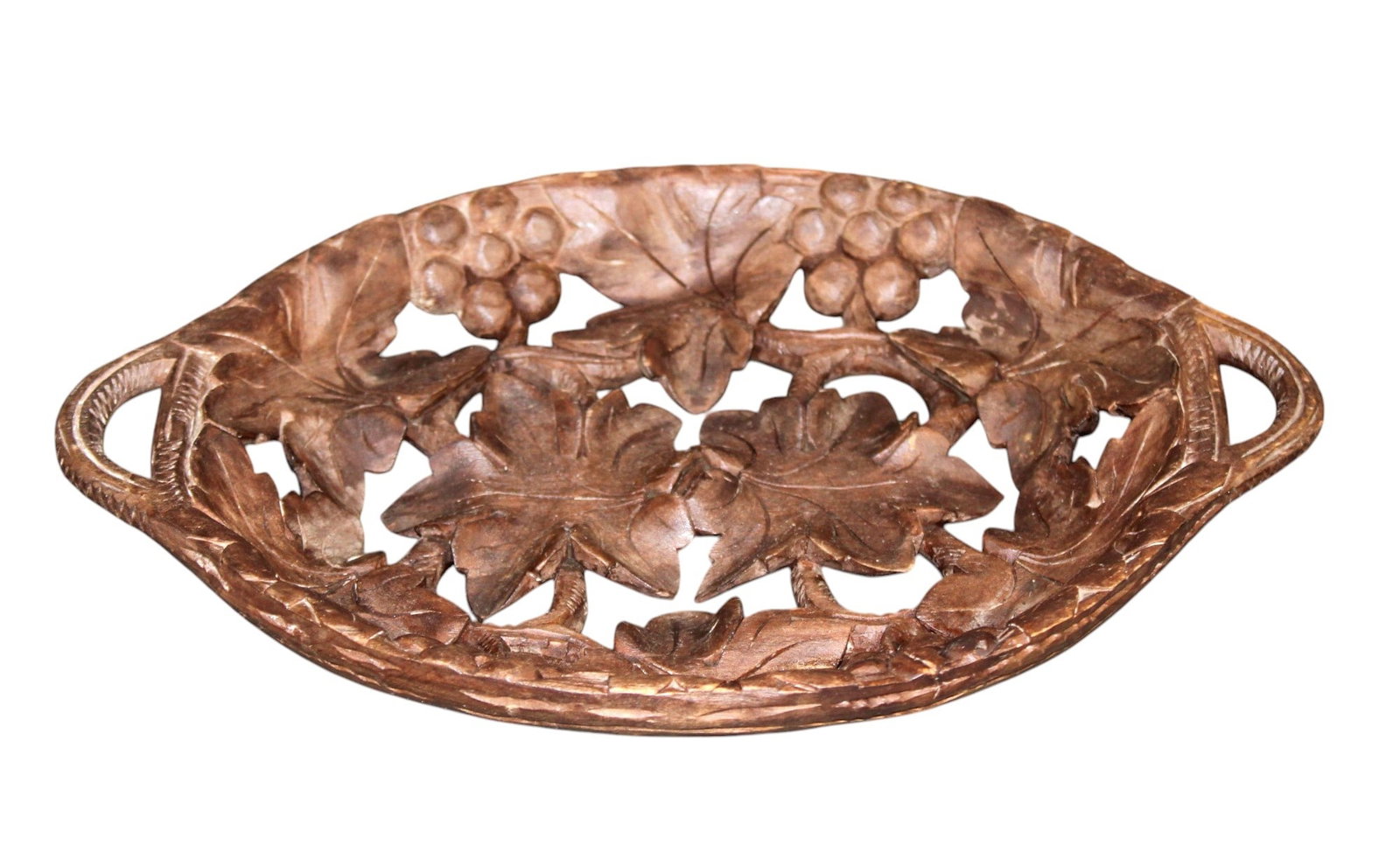 French carved walnut oval tray with grapevines: French pierce carved walnut oval tray with grapevines. Early 20th century. 1 1/4"h x 10 1/4"w x 6 5/8"d. Weight: 1lb.