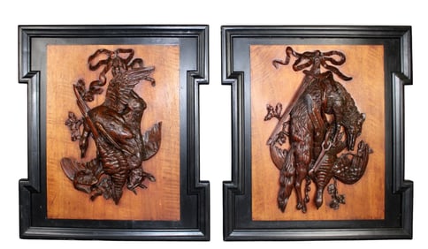 Pair of French relief carved trophy plaques in ebonized frames