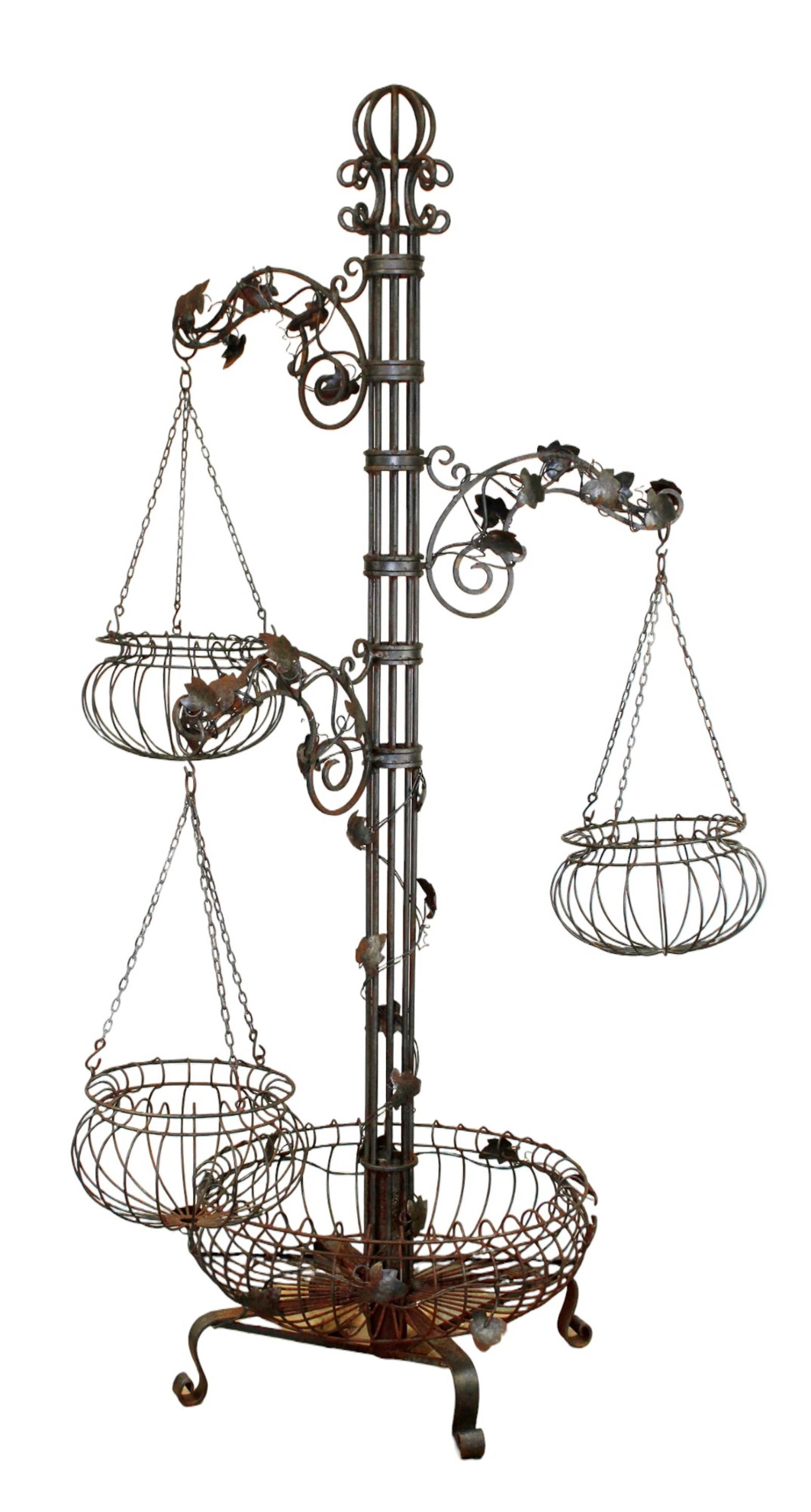Wrought iron tiered plant hanger: Wrought iron tiered plant hanger with ivy and rotating baskets. 82"h x 48"w