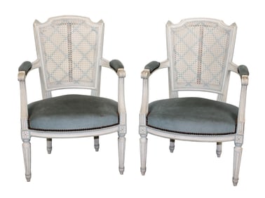 Pair of French Louis XVI style armchairs with caned backs and upholstered seats in painted finish