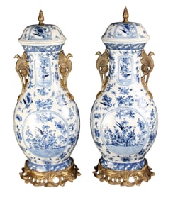 Pair of bronze and blue & white crackled finished ceramic lidded urns with winged griffin