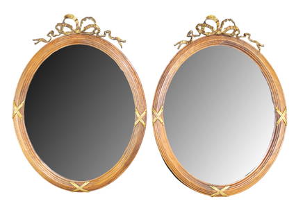 Pair of French Louis XVI style oval framed mirrors: Pair of French Louis XVI style oval framed oak mirrors with gilt metal ribbon focal. Early 20th century. 25 1/2"h x 18"w. Weight: 6lbs each