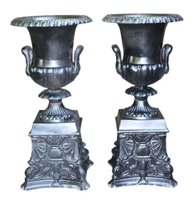 Pair of black aluminum urns on pedestals