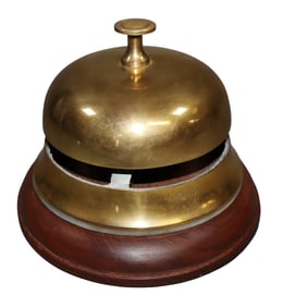 Large brass hotel bell on a wooden base