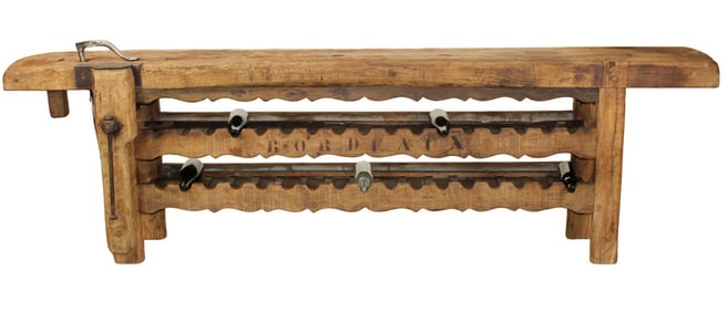 French carpenter's bench converted to wine tasting table with bottle storage