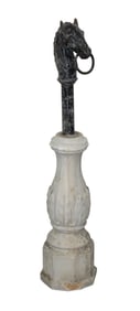 Cast iron horse head hitching post mounted on concrete pedestal