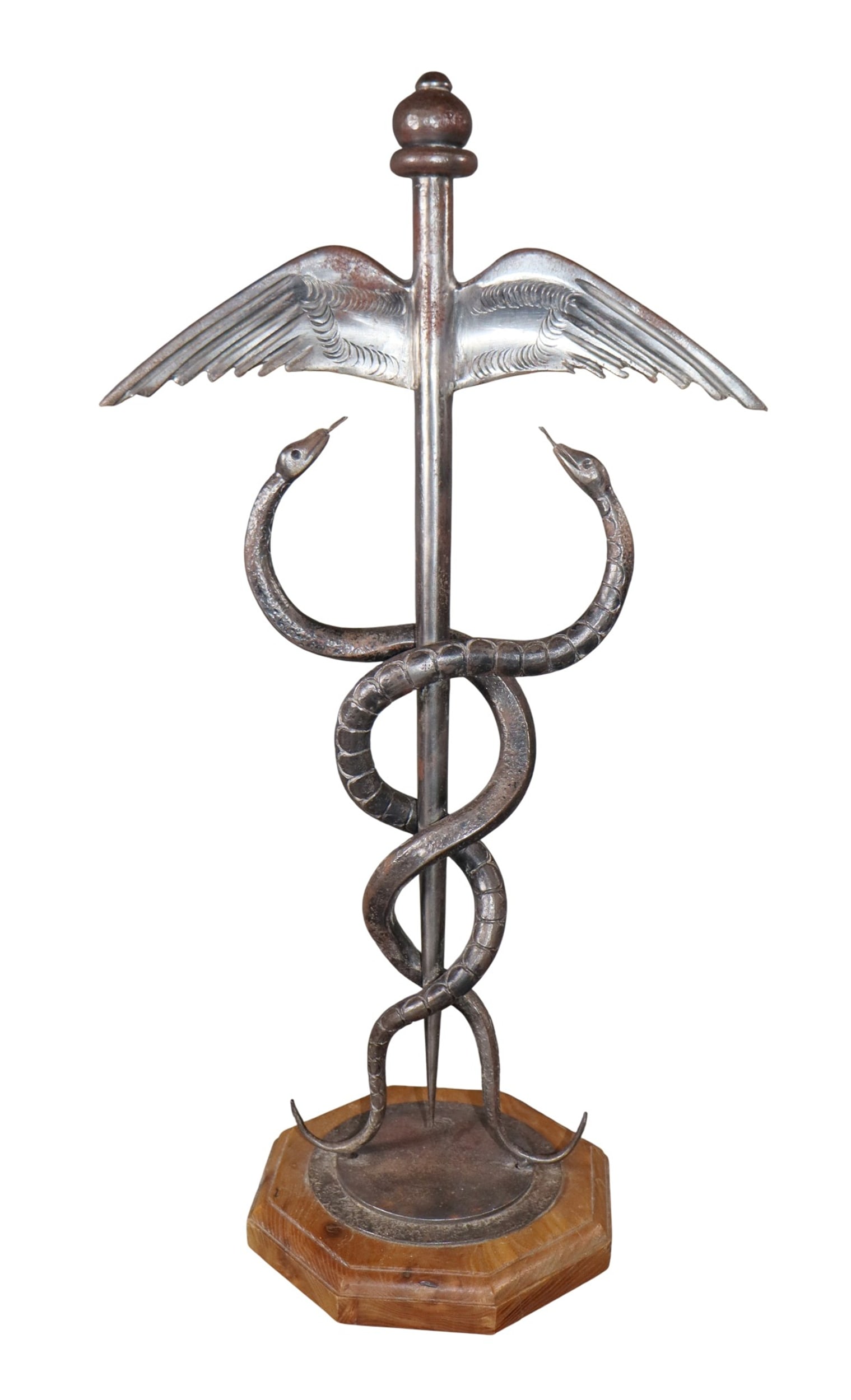 Caduceus sculpture in iron on wooden base: Caduceus sculpture in iron on wooden base. Makers stamp. Mid 20th century. 22"h x 11 3/4"w x 7 1/4"d. Weight: 7lbs