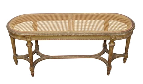 French Louis XVI style oval bench with gilt finish and a cane seat