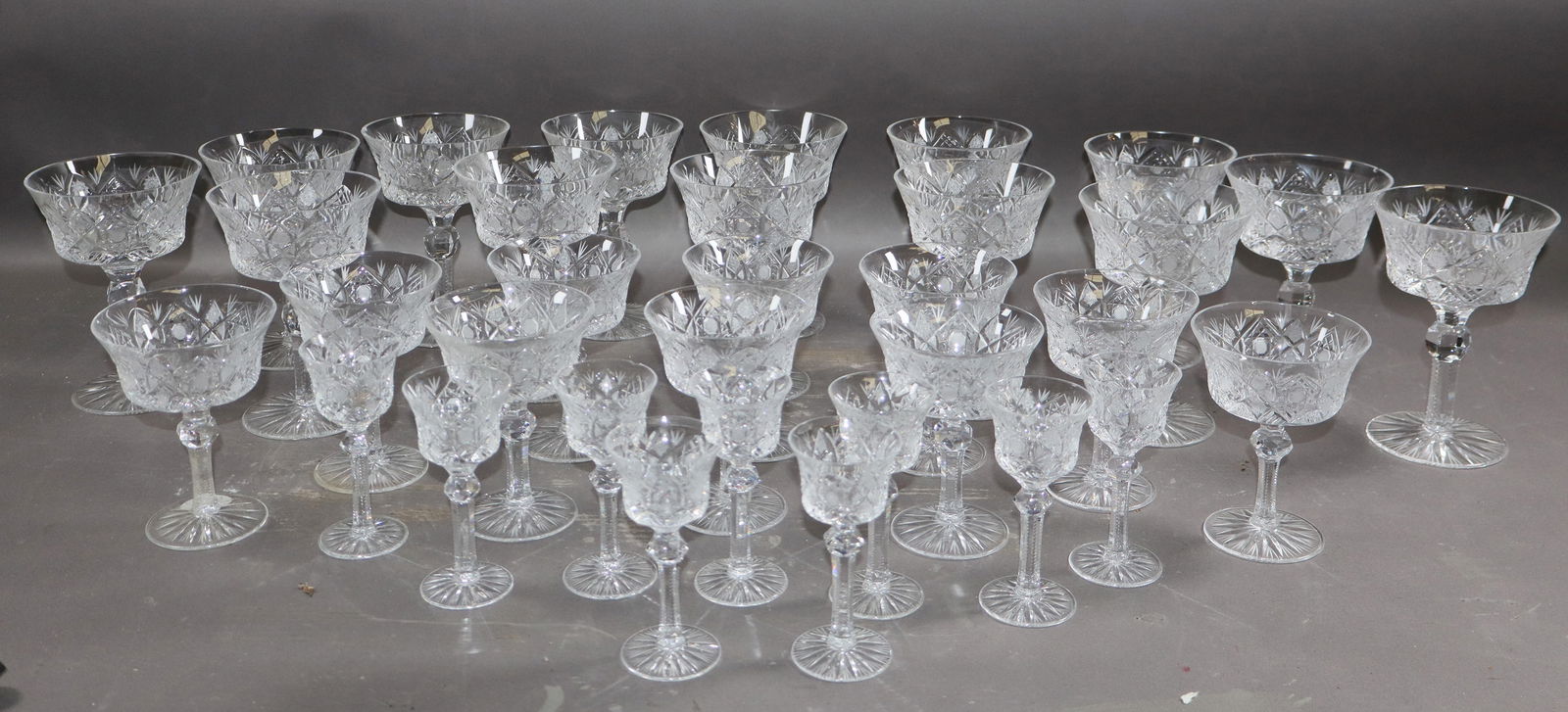 Lot of 34 American wheel cut crystal stemmed glasses: Lot of 34 American wheel cut crystal stemmed glasses. Wine glass: 14 total Champagne glass: 11 total cordial glass: 9 total 5 1/2"h x 3 7/8"dia 4 1/2"h x 3 1/2" dia 4"h x 1 3/4"dia. Weight: