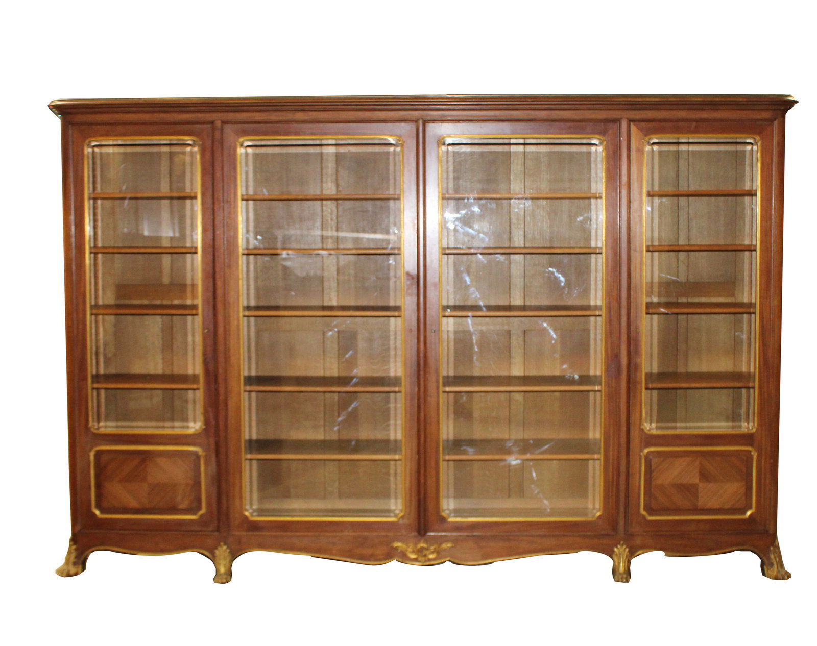 French Louis XV transitional 4 door bookcase with bronze paw feet: French Louis XV transitional 4 door bookcase in oak with beveled glass doors with bronze paw feet. Late 19th century. 79 1/2"h x 122"l x 20 1/2"d