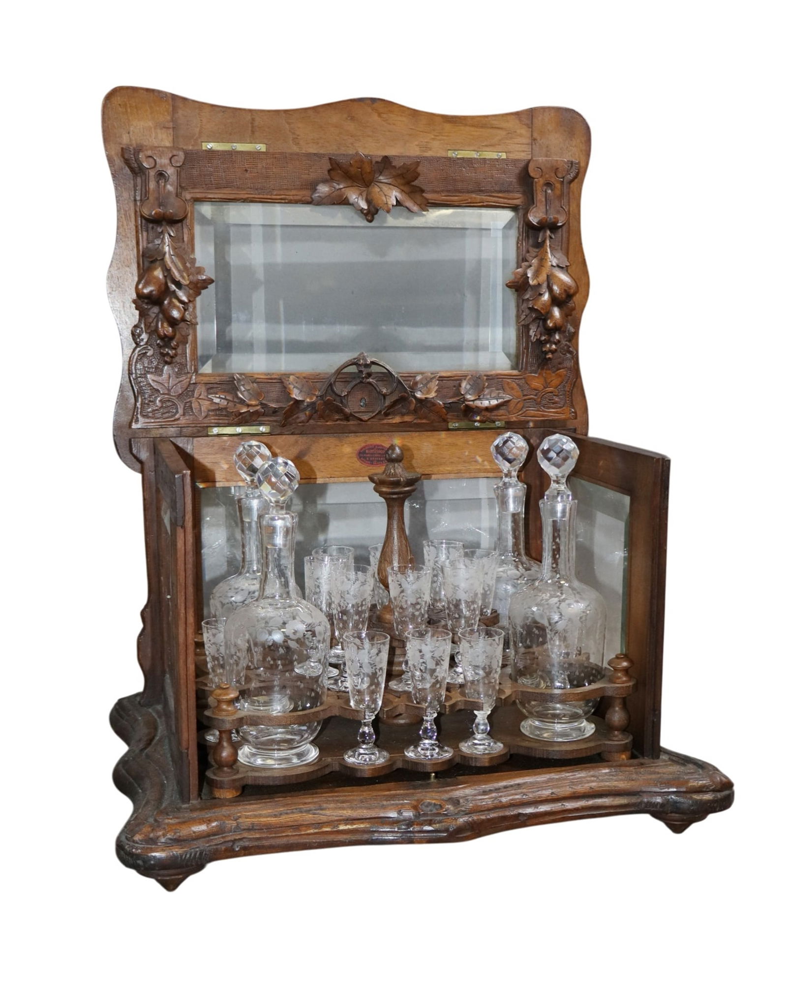 French carved walnut tantalus box set with etched glass cordial set: French carved walnut tantalus box set with etched glass cordial set. Makers label Bart sago, St Etienne. Late 19th century. 11 1/2"h x 16 1/2"w x 12 1/2"d. Weight: 16lbs