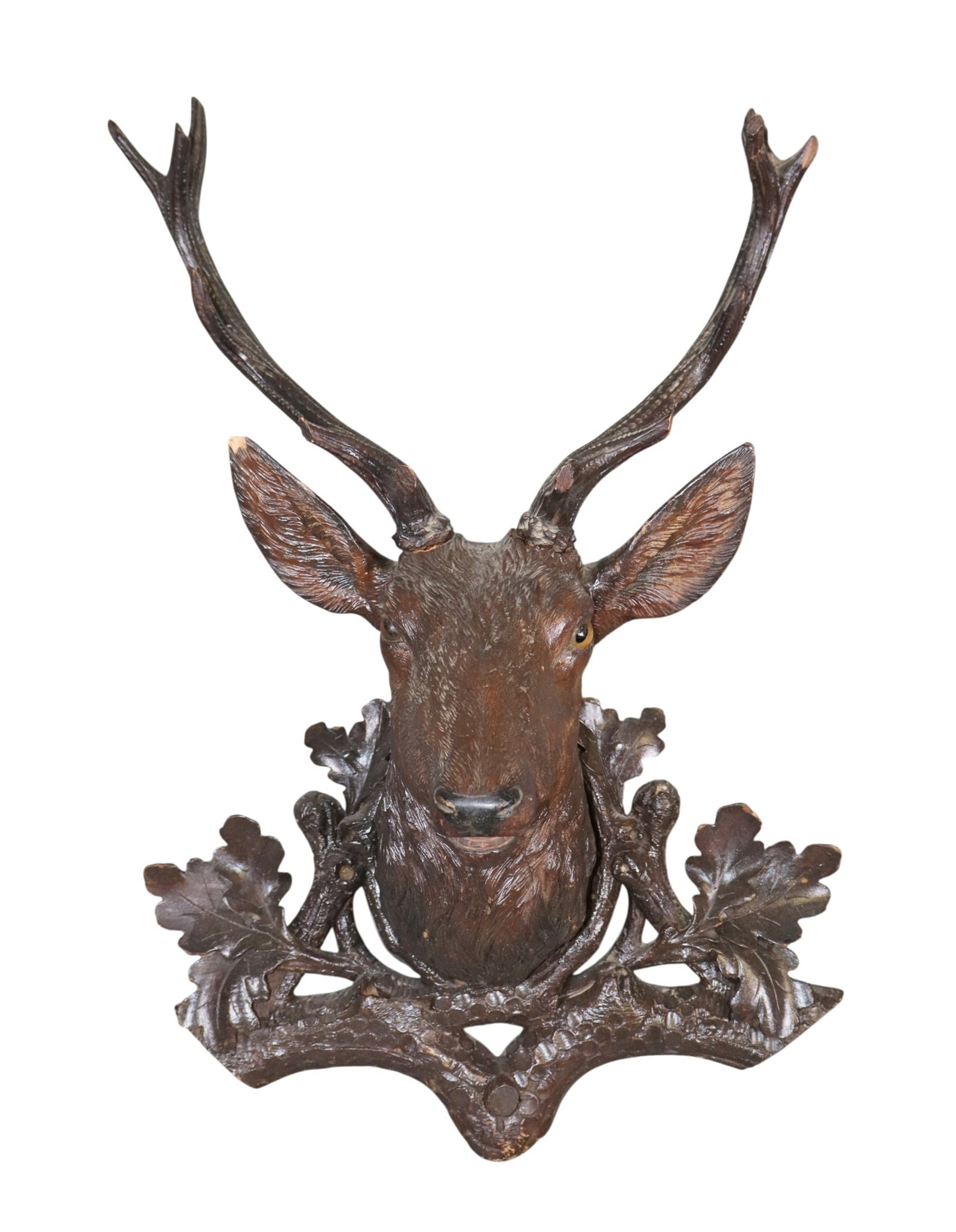 Black Forest deer head plaque carved in walnut and mounted on plaque with carved oak leaves: Black Forest deer head plaque carved in walnut with glass eyes and mounted on plaque with carved oak leaves. Late 19th century. 25"h x 16"w x 10"d Weight: 4lbs