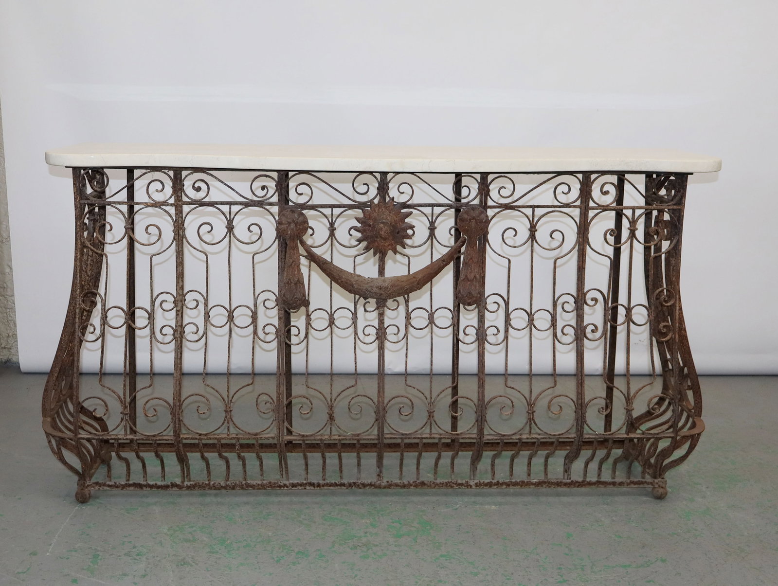 French wrought iron balcony mounted as console with travertine marble top: French wrought iron balcony panel mounted as console with a travertine marble top. 33""h x 59 1/2""w x 15"d."