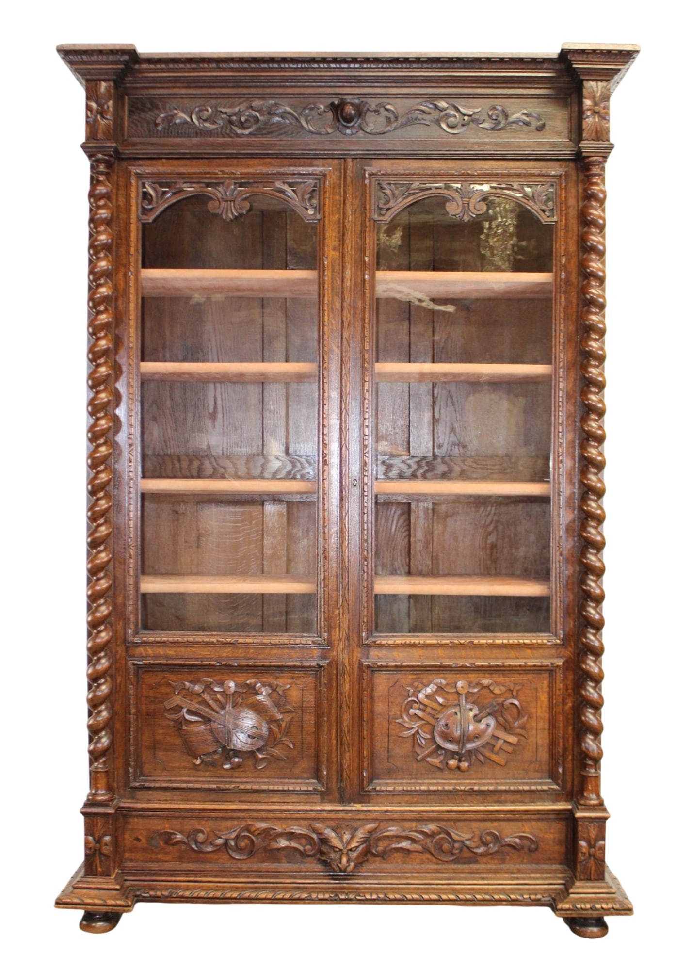 French Louis XIII 2 door bookcase in oak with barley twist columns: French Louis XIII 2 door bookcase in oak with barley twist columns. Relief carved attributes on the arts and music on doors. Late 19th century, 85"h x 55 1/4"w x 20"d