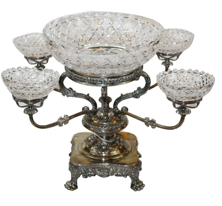 English silver 4-arm epergne with cut crystal cups and: center bowl. Base is decorated with scallop shell, acanthus leaves, all supported by 4 paw feet. Circa 1860. 11 3/8"h x 20 5/8"w