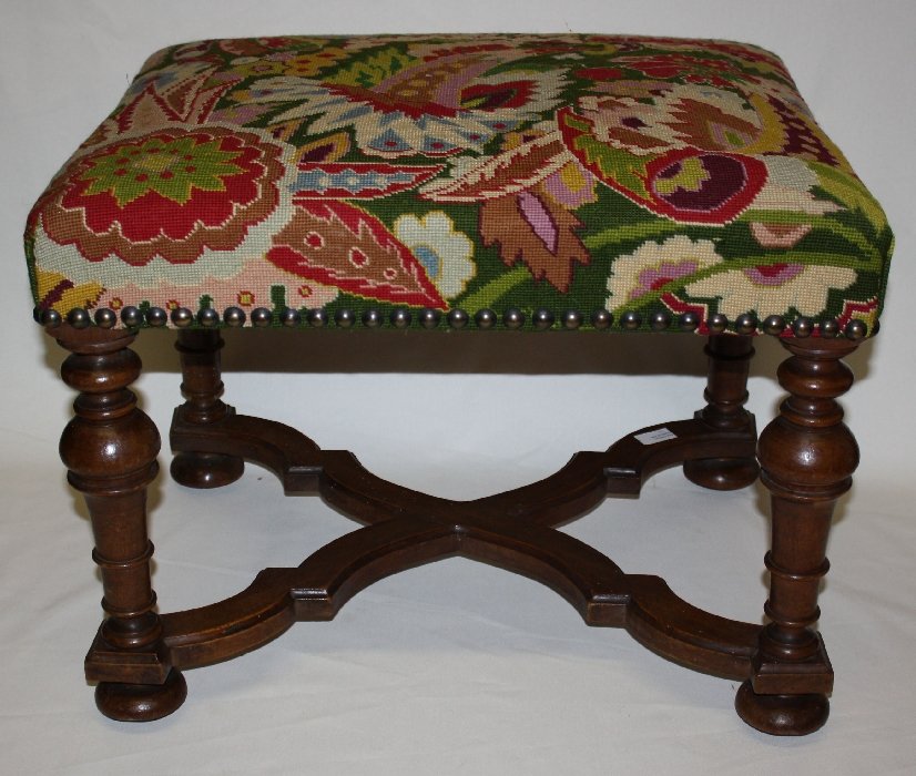 French Louis XIII carved walnut footstool: with shaped cross stretcher and upholstered in studded tapestry. Late 19th century. 23 1/2"w x 18"h