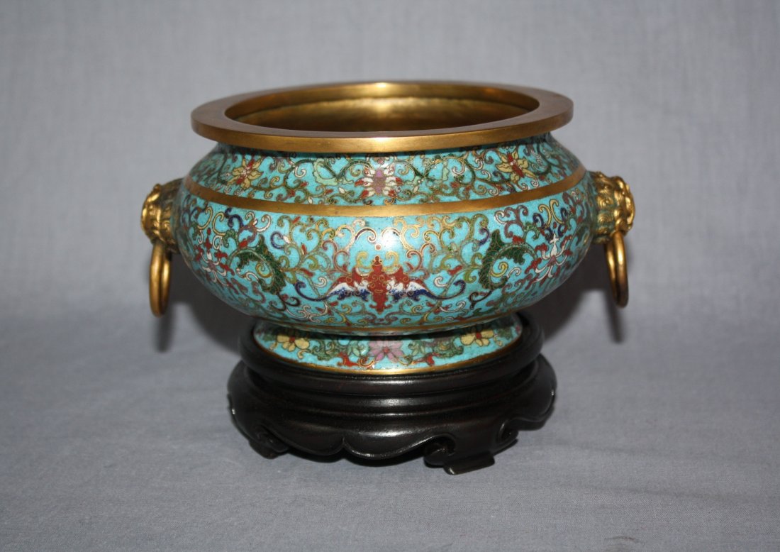 Chinese cloisonne bronze censor with QiLin handles: Shallow form round body decorated with cloisonne of colorful foliage and bronze figural QiLin handles holding rings on each side. Qian Long mark. On carved hardwood stand with formed tri-pod legs. 4 1