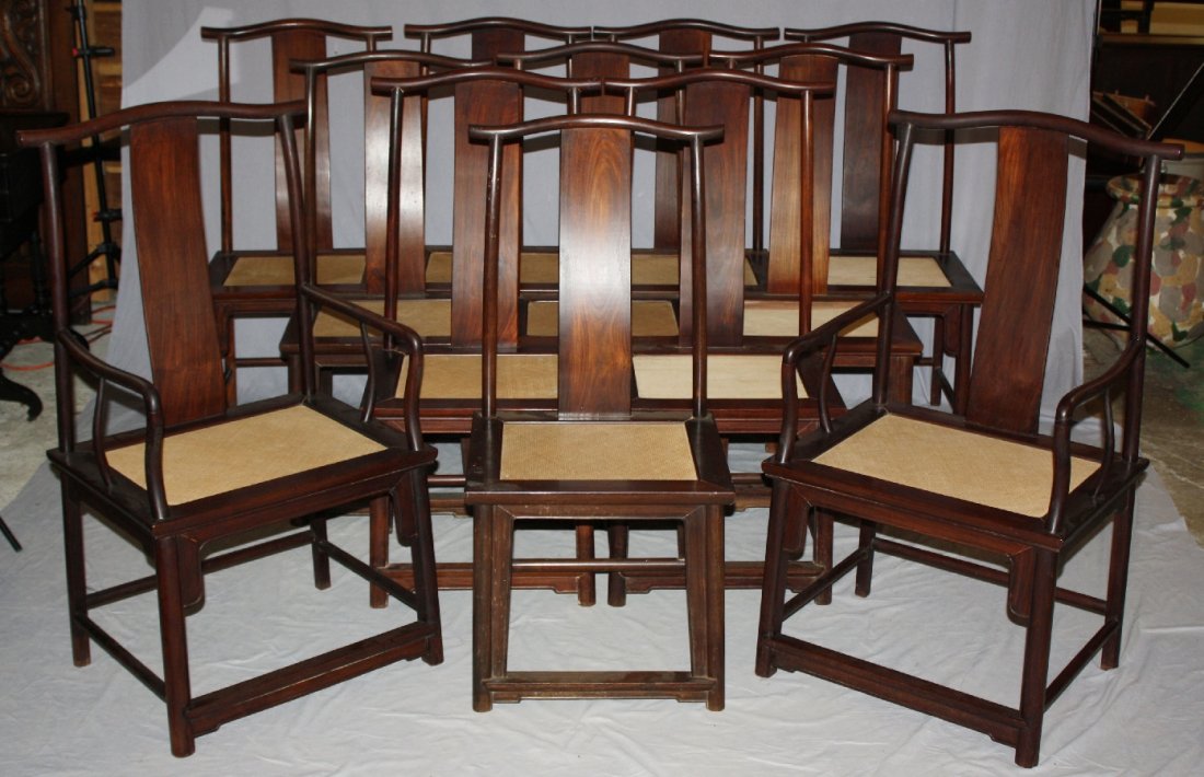 Set of 12 Chinese hard wood yoke back chairs. 2 arm, 10: Set of 12 Chinese hard wood yoke back chairs. 2 arm, 10 side. Asian hardwood. 10 chairs with inset woven seats and 2 chairs with inset plank seats. Estate of the Late Evangeline Brewster Johnson Merri