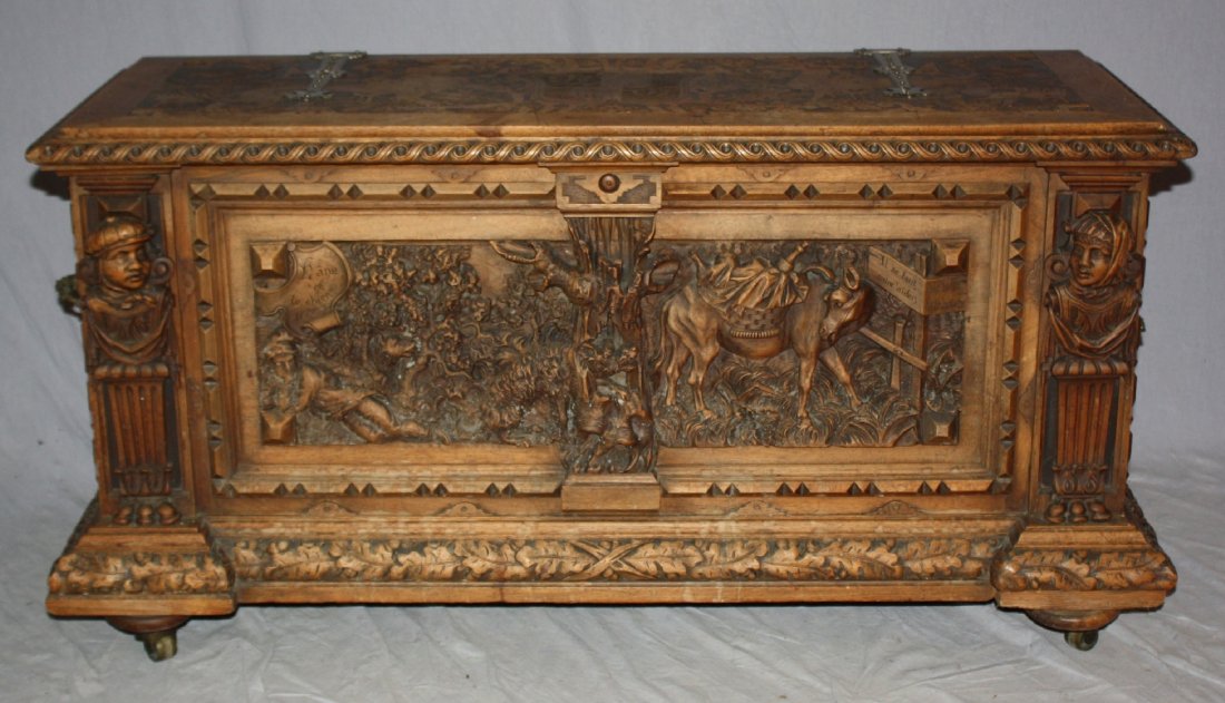 A very unusual French carved walnut marriage chest: Front panel of chest is elaborately relief carved with a scene from a Jean de la Fontaine fable L'ane et Le Chien (The donkey & the dog). The top panel is incised carved with a coat of arms featuring 