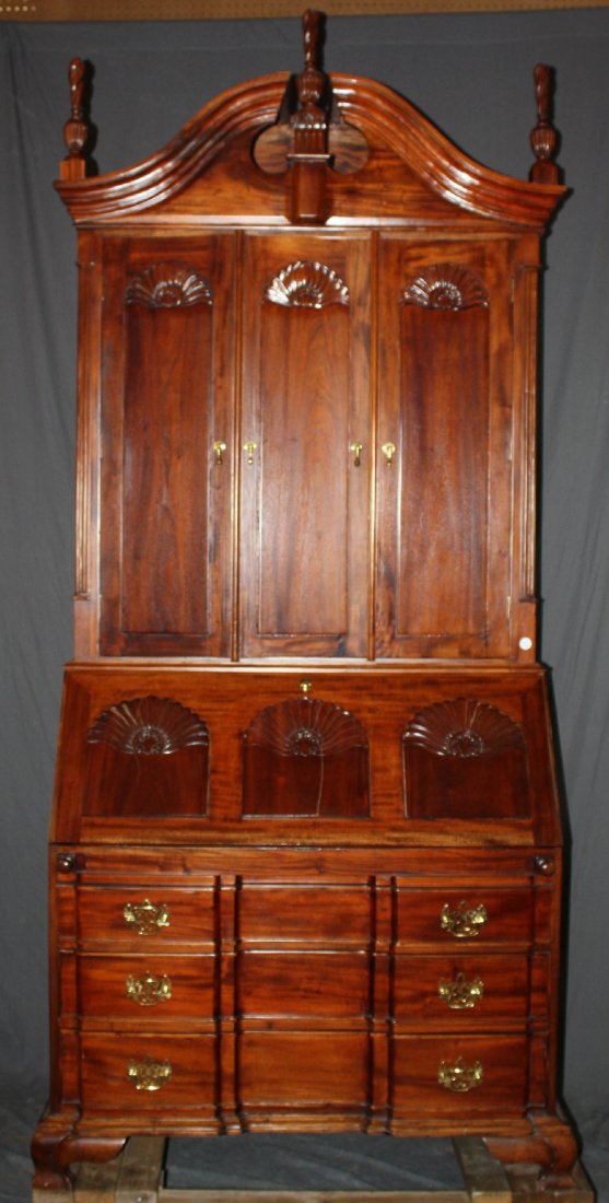 Carved mahogany block front secretary: With folding doors, open pediment with finials, shell carvings & brass pulls. Interior is fitted with cubby holes. 98"h x 48"w x 22.5"d