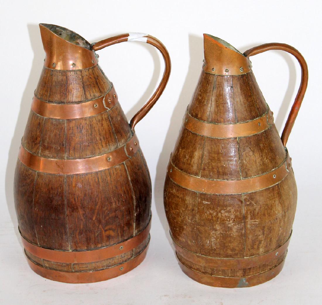 Lot of 2 French wine pitchers from Alsace: Lot of 2 French oak wine pitchers wrapped in copper. From Alsace. 11 3/4"h & 11 1/2"h