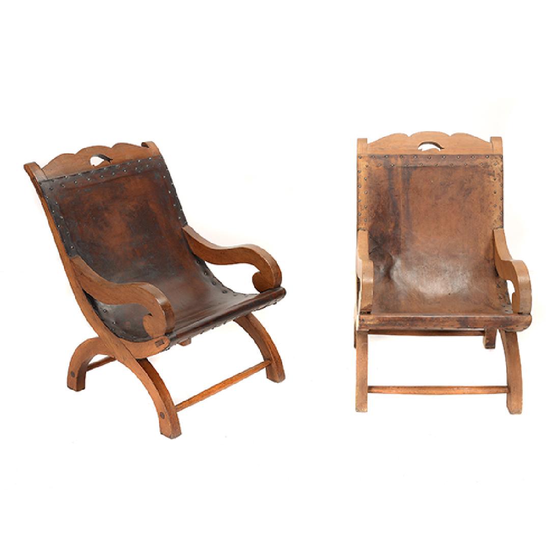 Pair of Spratling Chieftain Chairs: Pair of Spratling Chieftain Chairs, Each sling back chair with stretched leather back and seat, branded "WS Taxco, Mexico", Circa 1938 {Dimensions 32 x 21 x 23 inches} [one chair has a tear in the lea