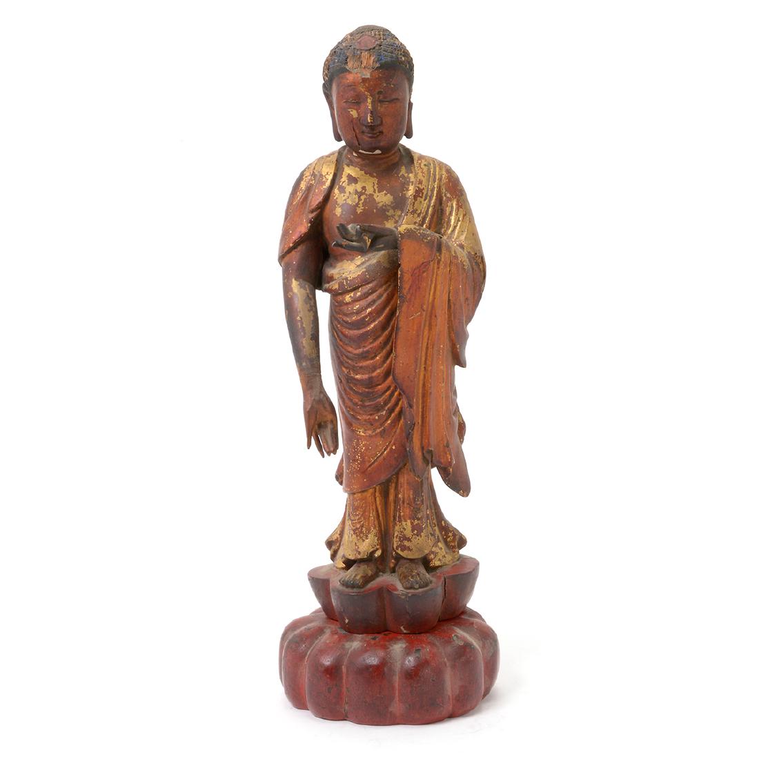Gilt Lacquered Wood Figure of Buddha, Qing: Gilt Lacquered Wood Figure of Buddha Posed standing upon a carved foliated base, his elongated right arm lowered and his left hand holding a cup. Qing Dynasty {Height: 16 3/4 inches (42.5 cm)} Provena