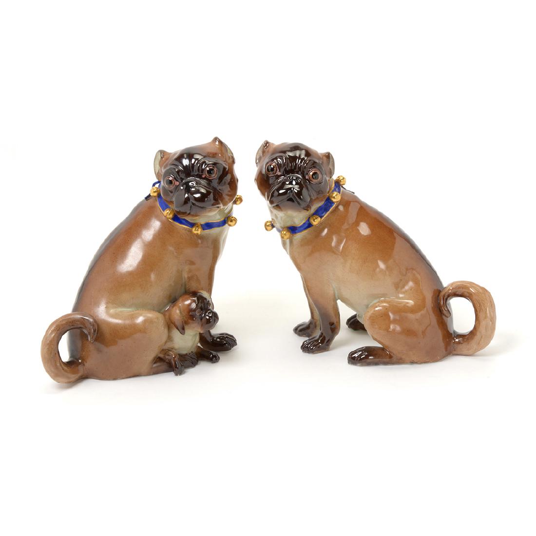 Pair Meissen Porcelain Pugs: Pair Meissen Porcelain Pugs. Comprised of a male Pug figure with a blue collar, and a female blue-collared Pug modelled with a pup with uncropped ears. {Height of both 7 inches} [slight loss to ribbon