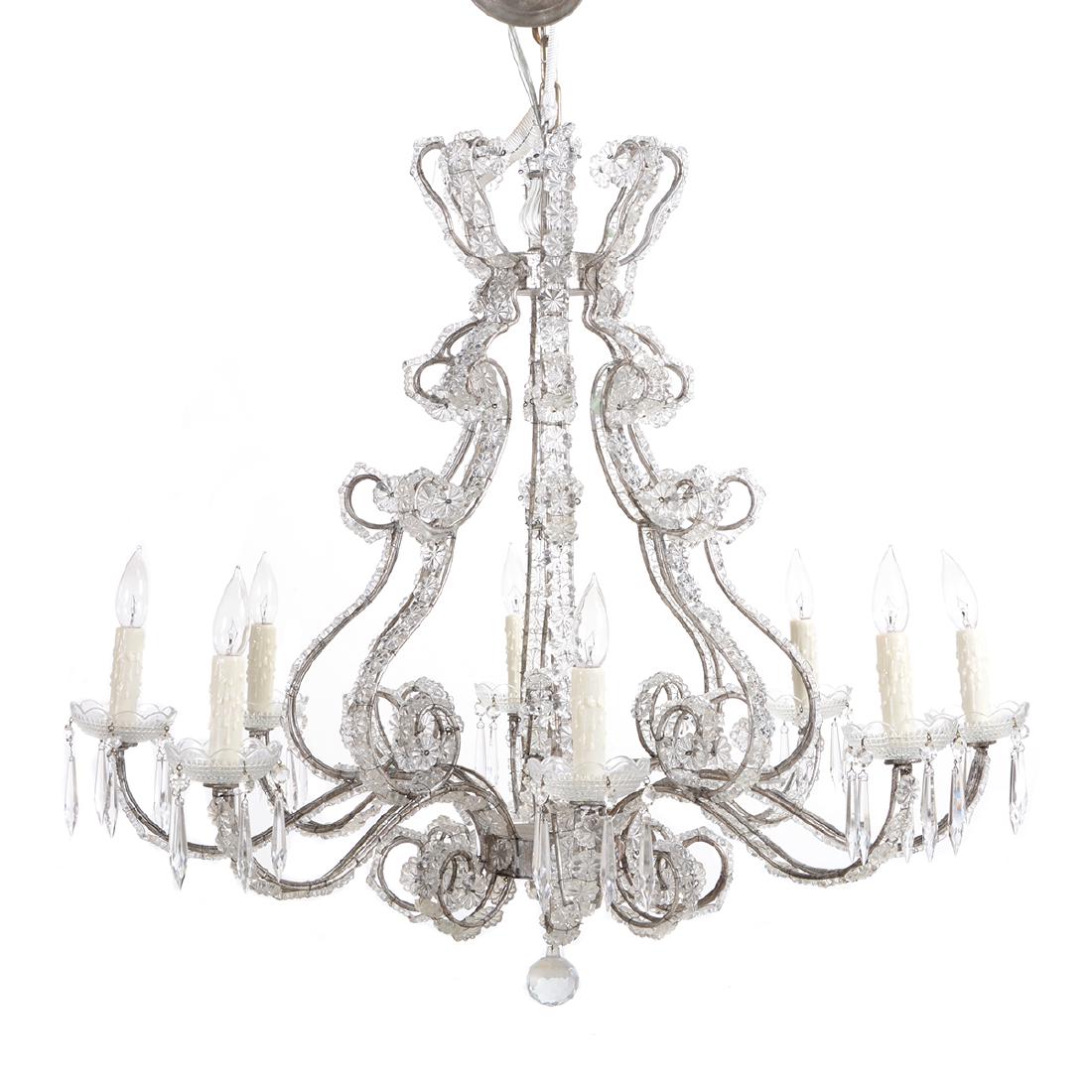 Italian Rococo Glass and Metal 'Novella' Eight Light: Italian Rococo Style Glass and Metal 'Novella' Eight Light Chandelier. The corona above an open cage issuing eight scrolledcandlearms with glass bobeches above scrolled pendants, partially mounted wit