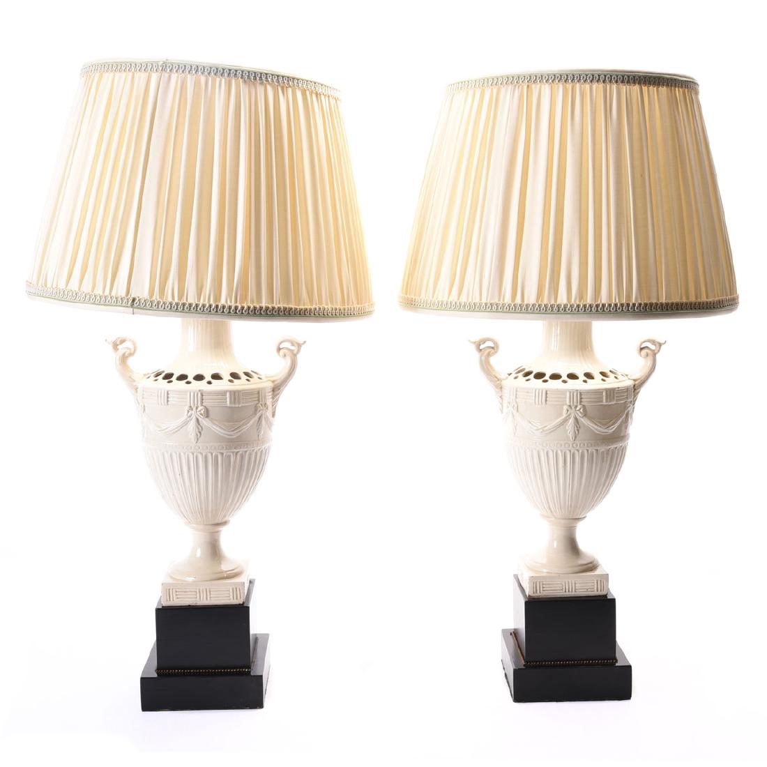 Pair of European Creamware Urns with Green Leaf Banded: Pair of European Creamware Urn Form Lamps. Each of fluted urn form with leaf modeled handles raised on integrated socle, atop ebonized stepped square bases, now mounted as lamps {Height of urn 16 inch