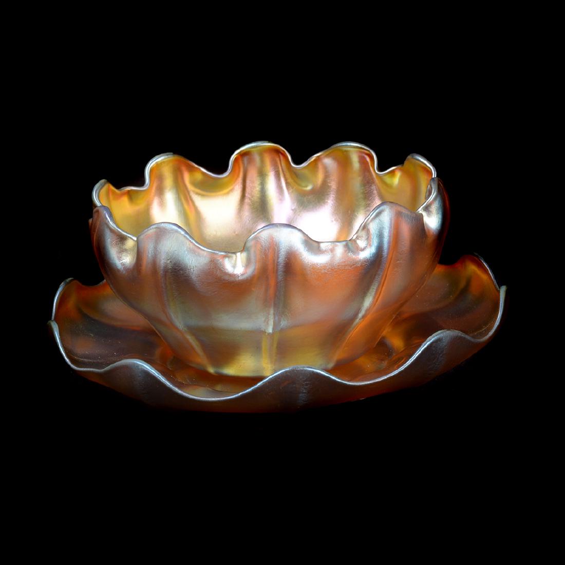 Tiffany Studios Gold Favrile Finger Bowl and Underplate: Tiffany Studios Gold Favrile Finger Bowl and Underplate. Iridescent Gold Ruffled Edge Bowl, with associated Underplate. {Dimensions: Bowl 2 1/2 x 4 3/4 inches, Underplate 1 1/4 x 6 1/4 inches.}