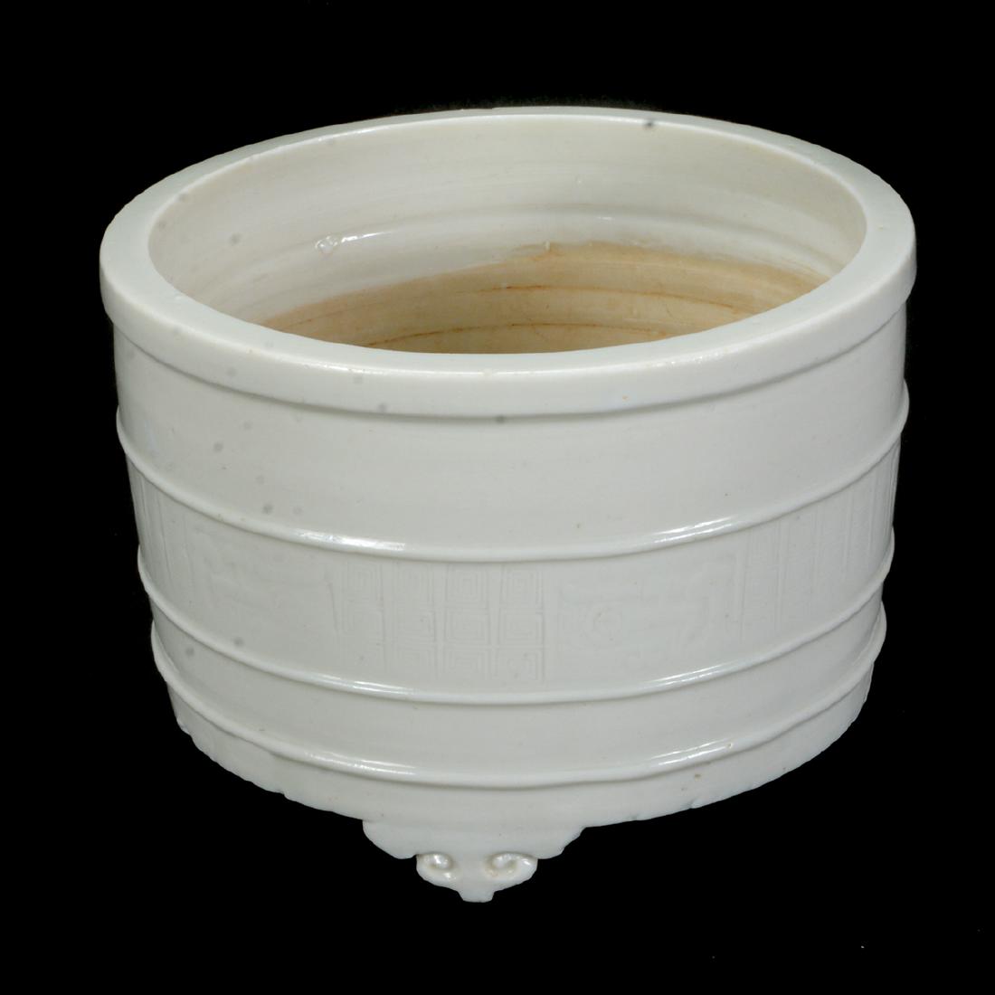 Small Chinese Dehua Porcelain Tripod Censer: Small Chinese Dehua Porcelain Tripod Censer. The censer raised on three ruyi-feet and decorated with three shallow bands around the exterior, the central register is incised with a taotie and key-fret