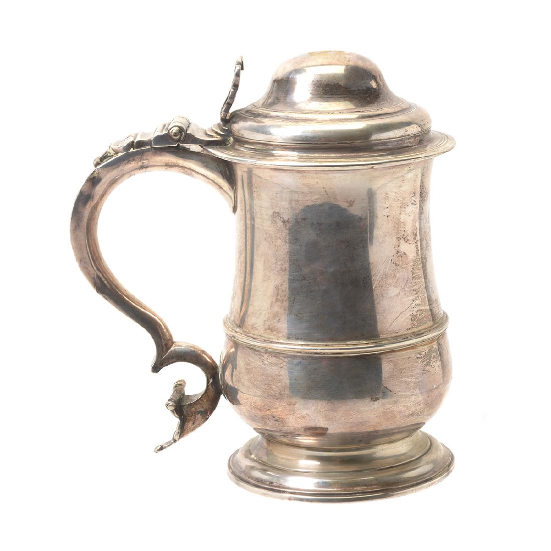 English George III Silver Tankard by John Muns dated: English George III Silver Tankard by John Muns dated 1765 of baluster form, with rib to low waist and c-scroll handle, having scrolling upper terminate, and bar and ball lower terminate. Muns listed a
