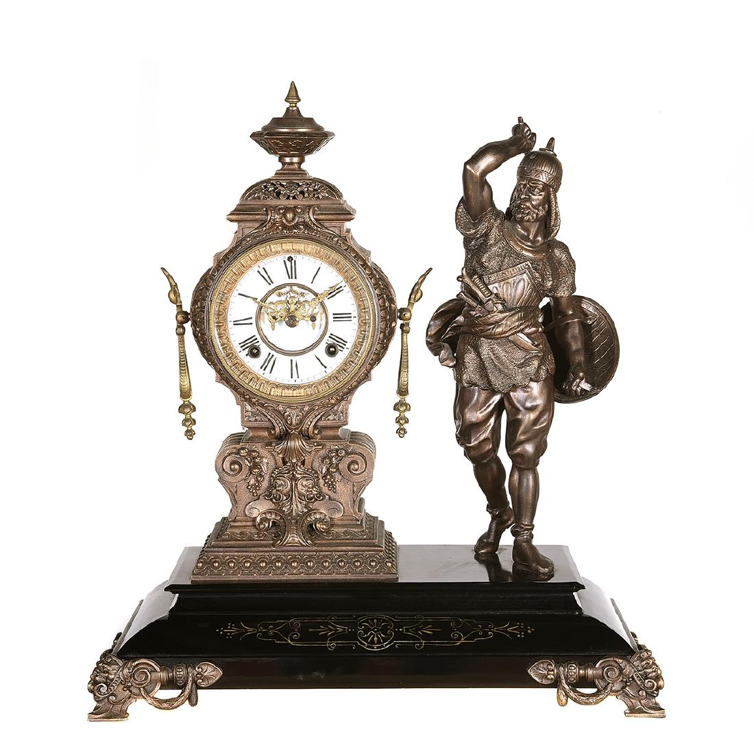 Ansonia Metal Figural Mantle Clock with Figure of a: Ansonia Metal Figural Mantle Clock with Figure of a Turkish Soldier on an Enameled Metal Base. Soldier carrying a shield and hatchet next to a baroque style clock with a roman numeral dial, both set o